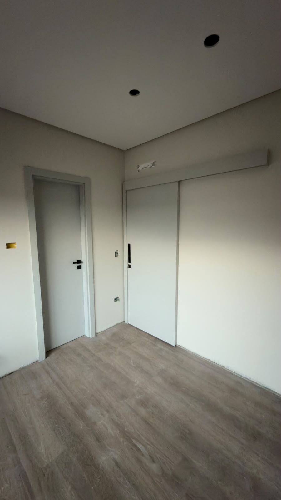 Quarto com porta de correr, porta de giro e piso amadeirado cinza